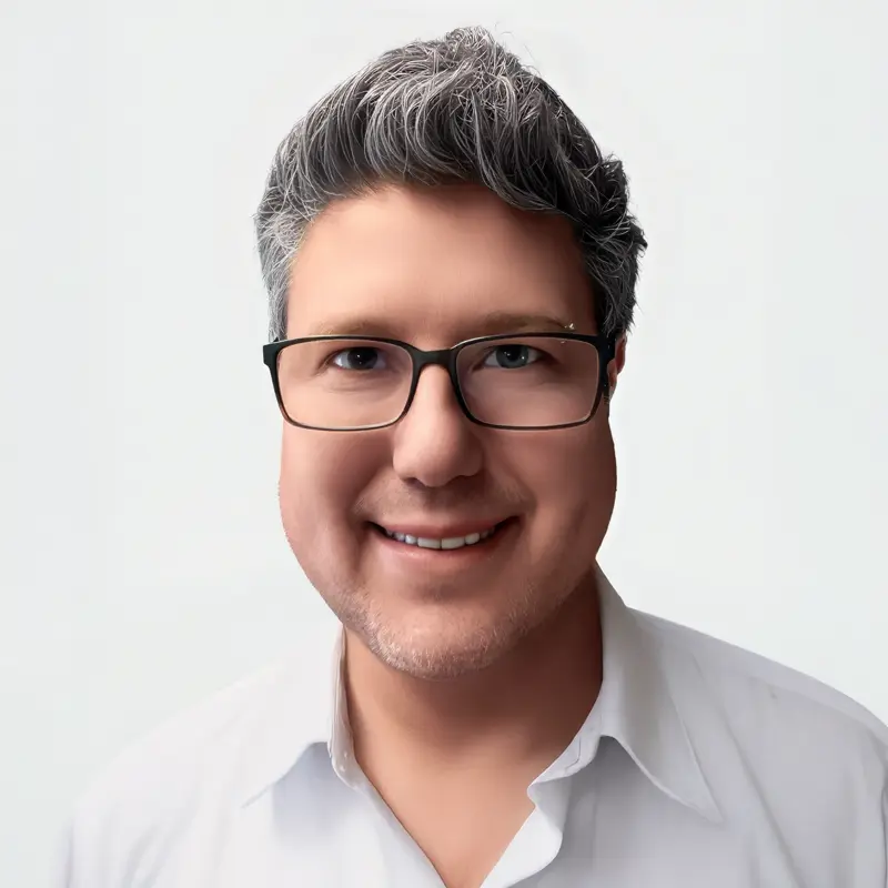 Retrato de Juan Diego, creador del blog Juan Shops, sonriendo con camisa blanca y gafas